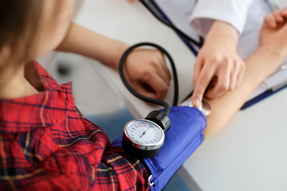 Medical assistant measuring someone’s blood pressure