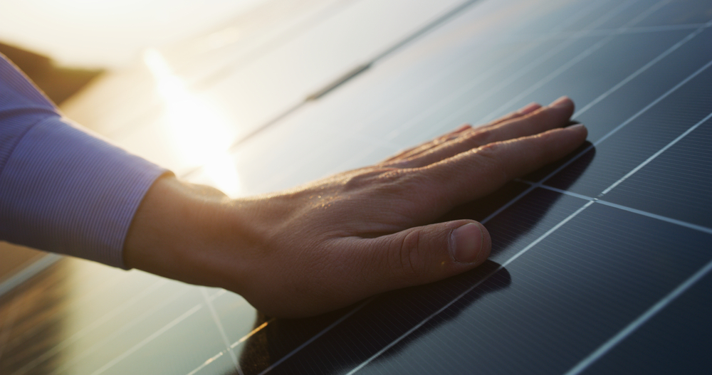 Solar Energy Technician Putting Hand on a Solar Panel